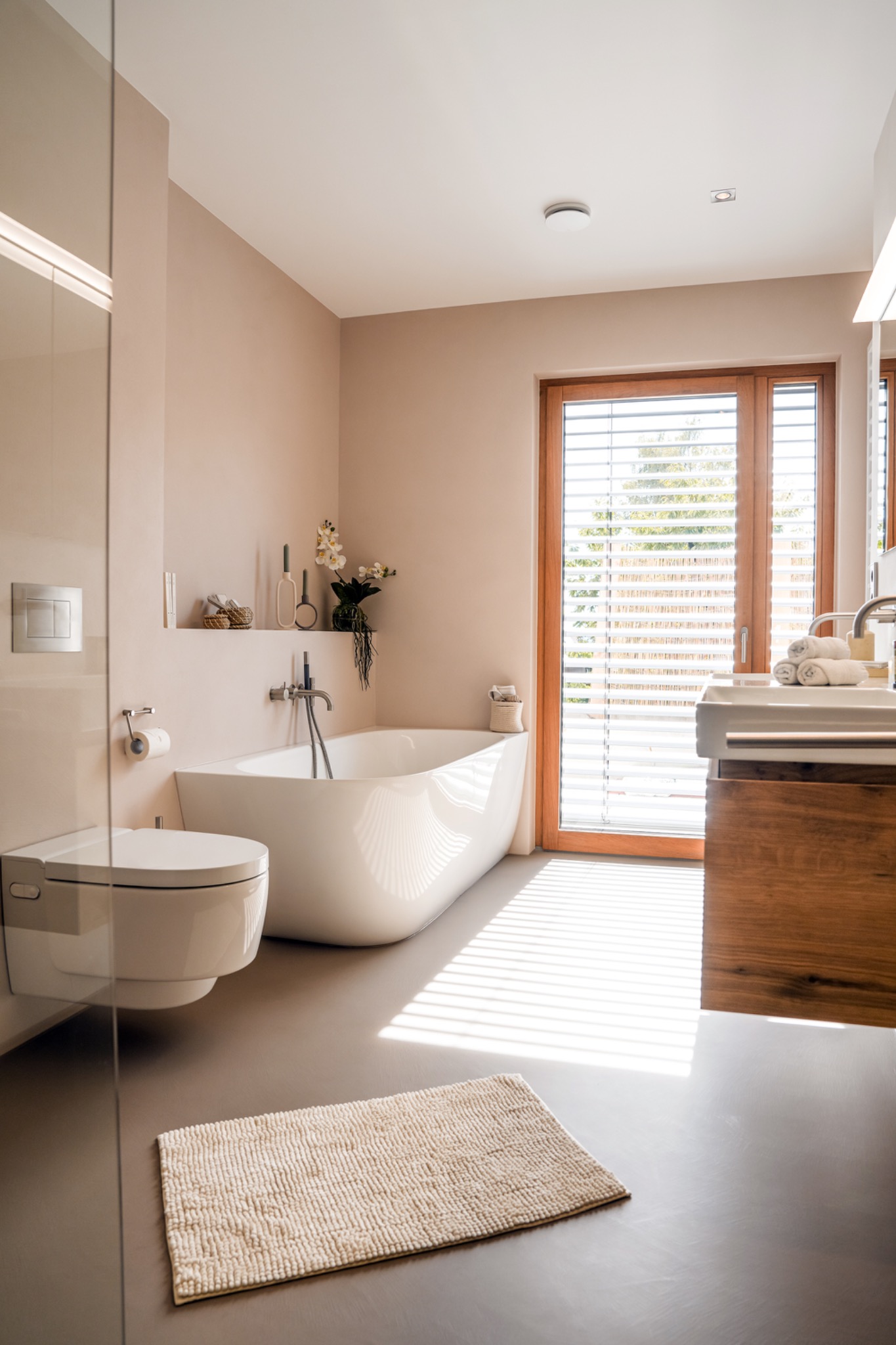 Fugenlose Wellness-Architektur mit Badewanne und warmen Oberflächen